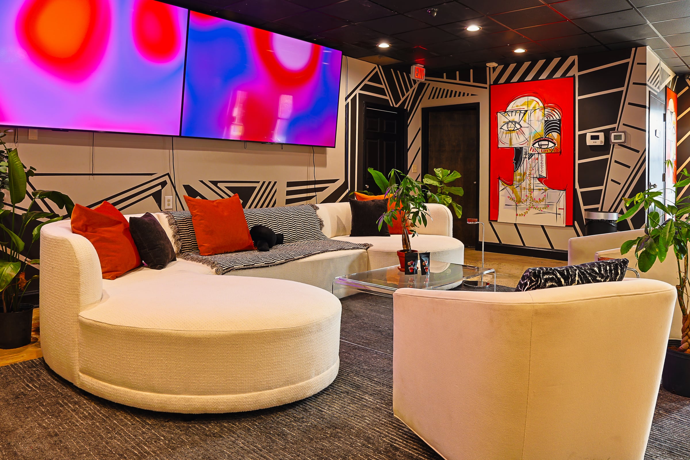White sofas with LED screens and face murals