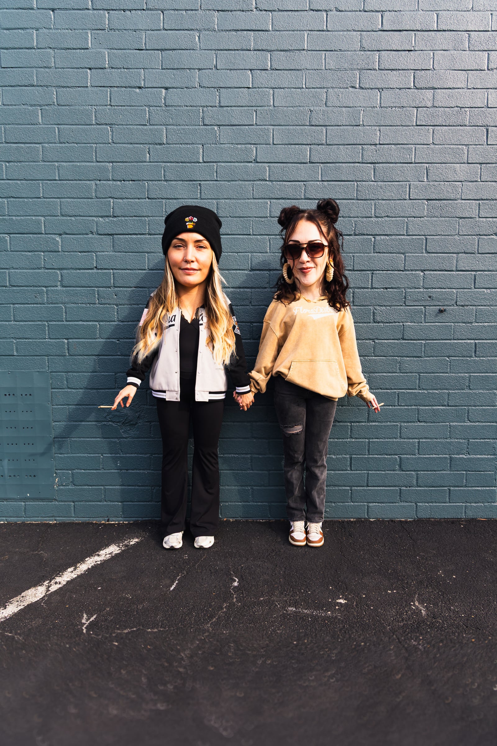 Two women in Flora merch holding hands