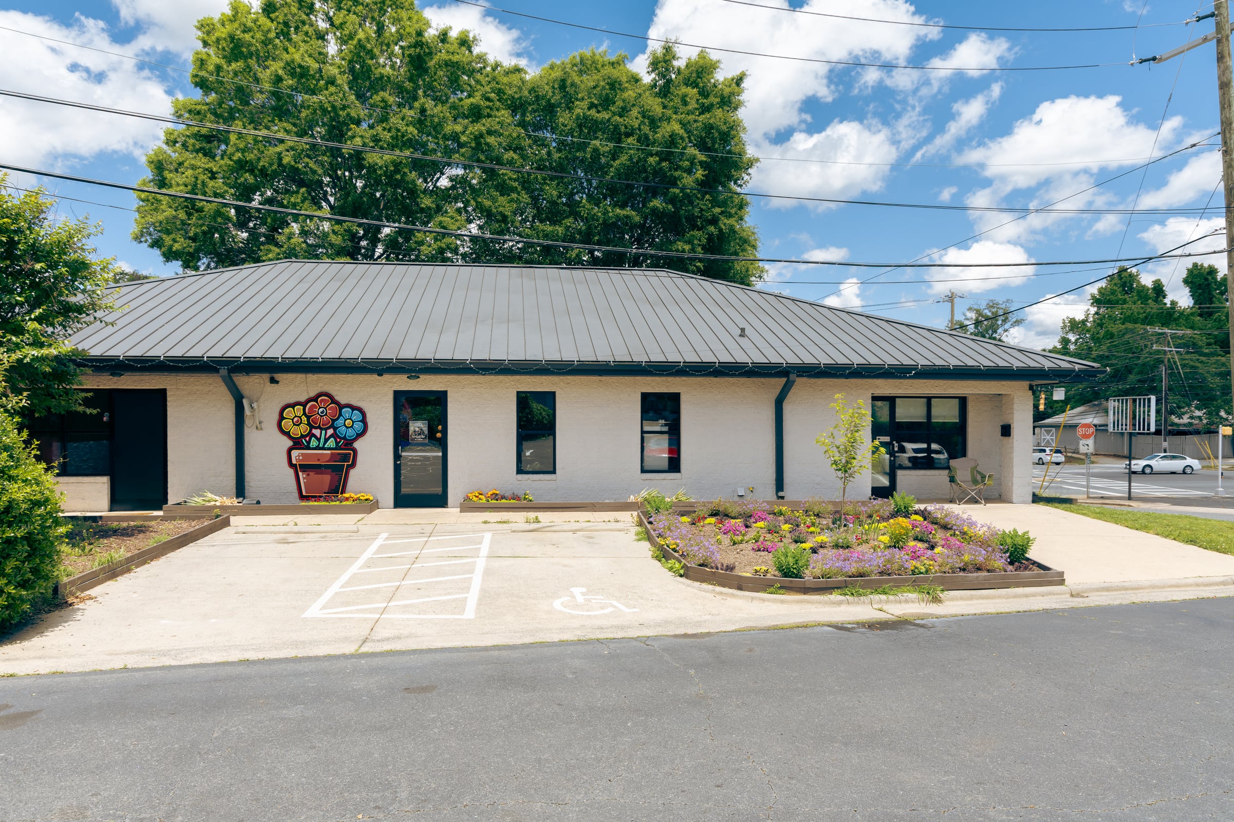 Wide storefront with mural and landscaping